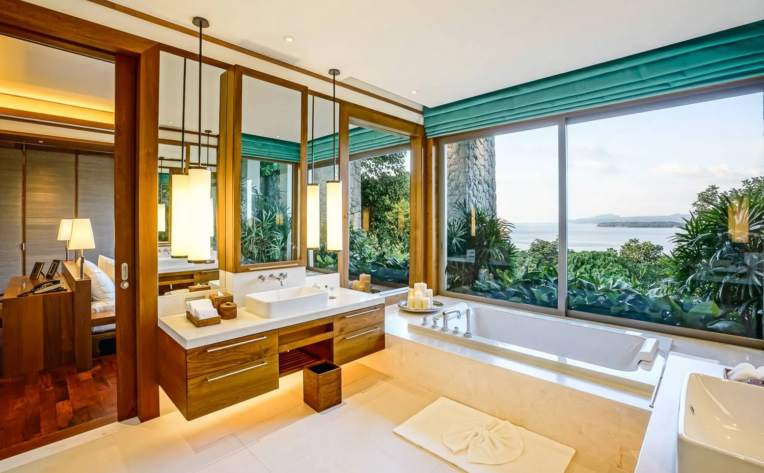 A bathroom with a soaking tub set in front of a window overlooking the sea