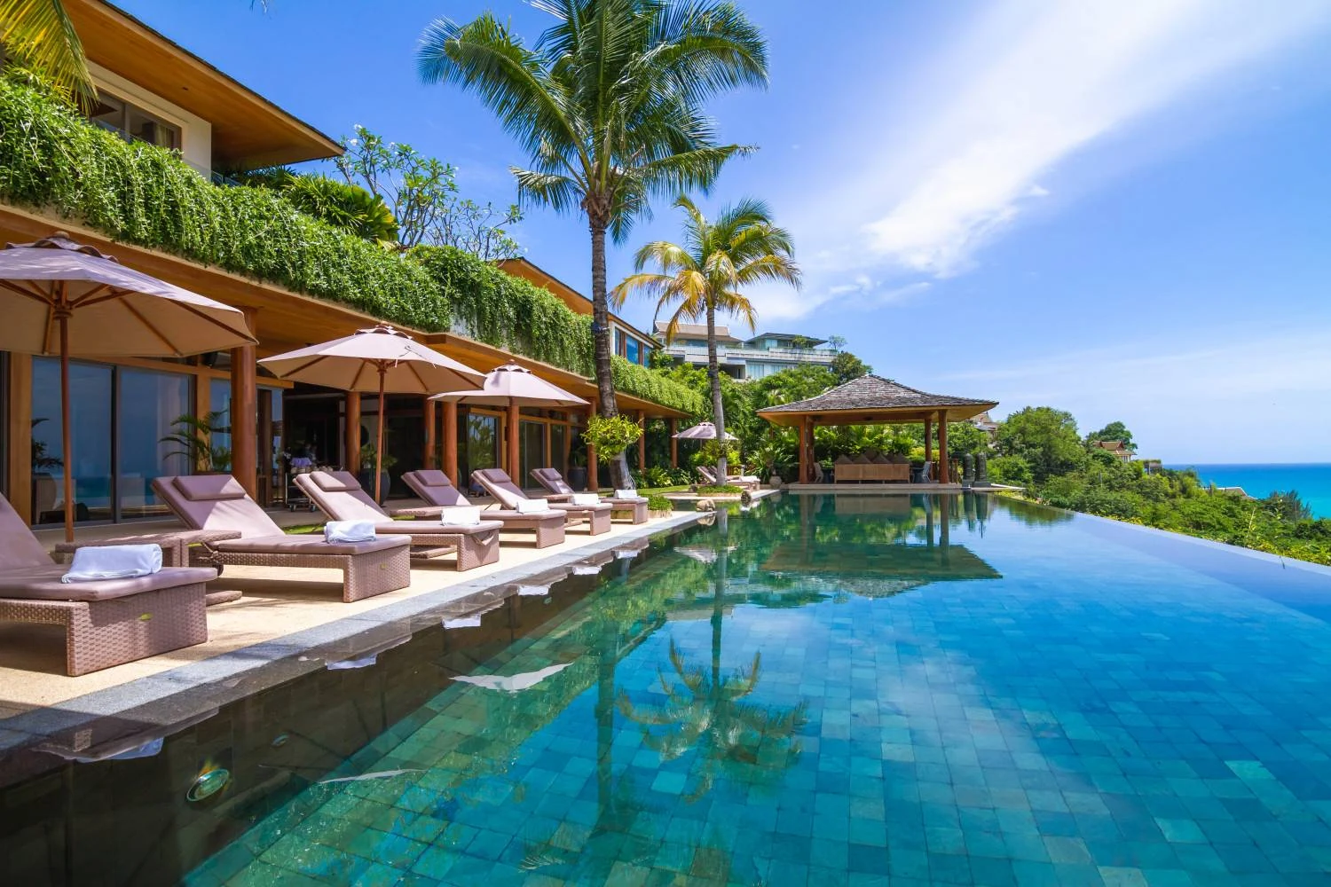 Sun loungers along the infinity pool beside the living pavilions