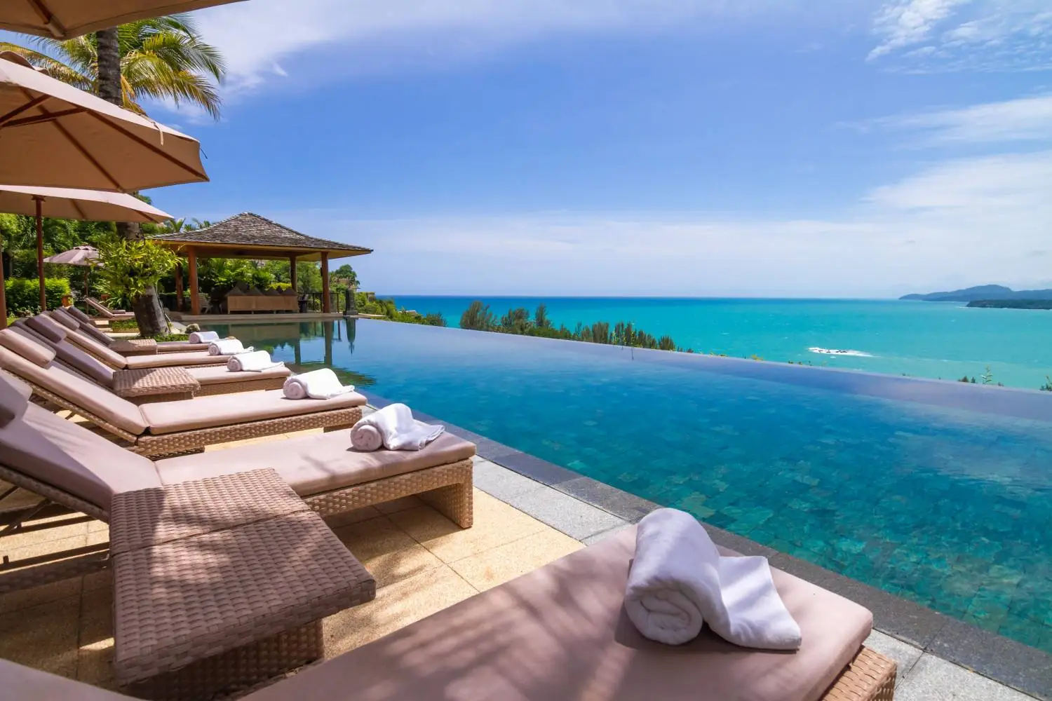 Poolside loungers with rolled towels overlooking the Andaman Sea