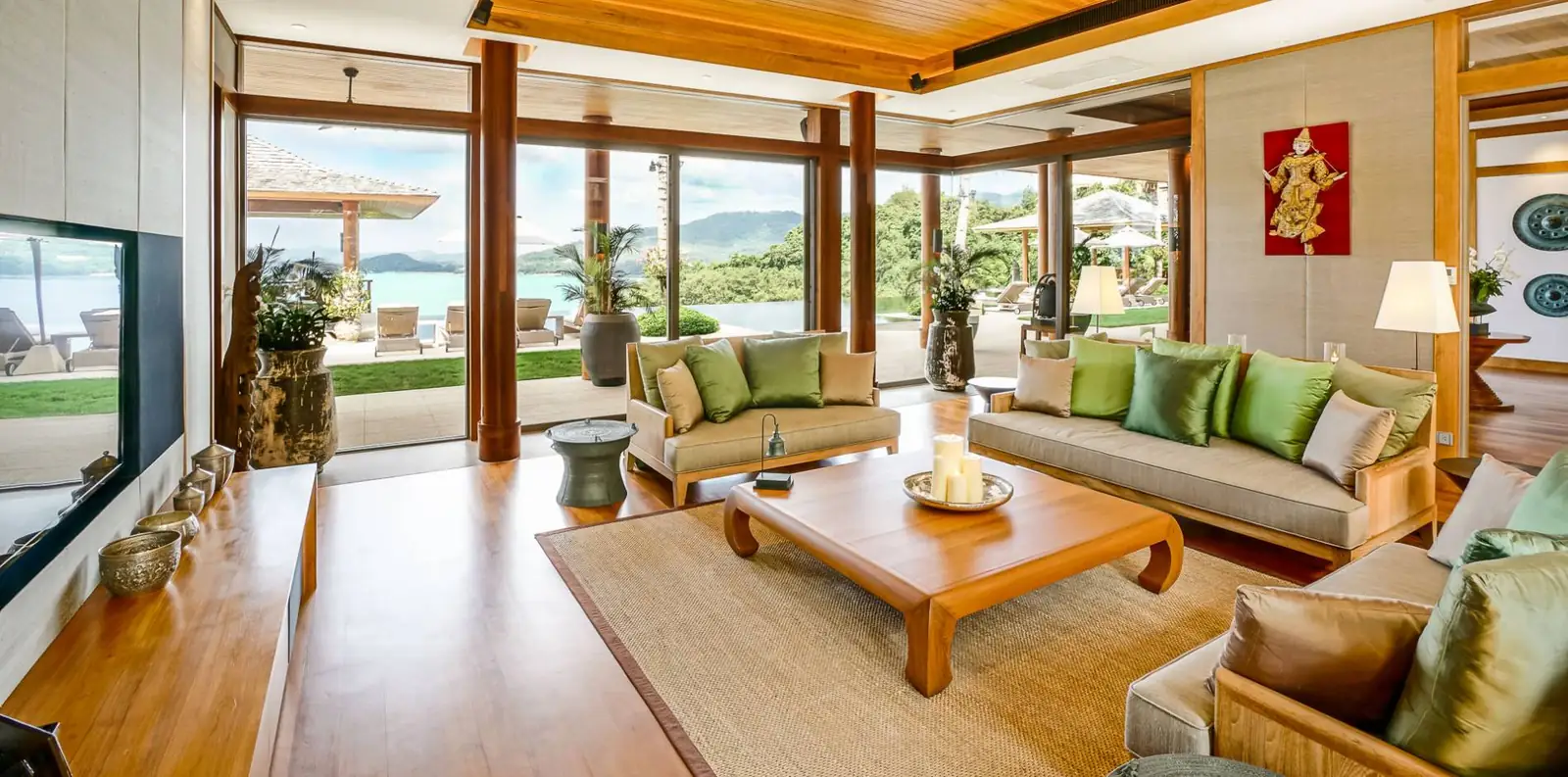 Open-plan living area with glass walls opening to the terrace and sea view