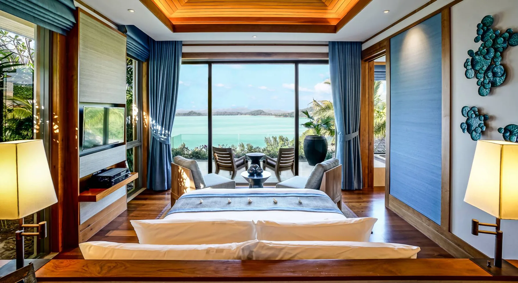A bedroom with a bed positioned to face a window with a sea view